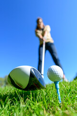 Golferin schlägt einen Ball vom Tee
