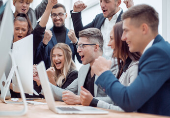Fototapeta premium jubilant business team looking at the computer monitor