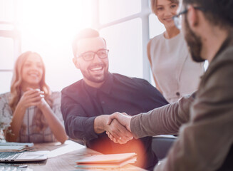 background image of the handshake of business partners in the office