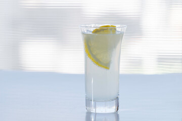 窓際に置かれたレモンスライスの入った炭酸飲料