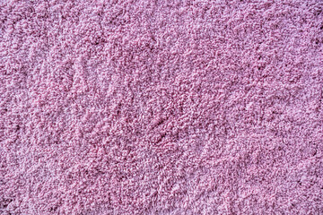 Long pile carpet texture. Abstract background of shaggy pink fibers.