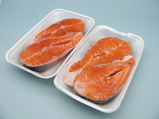Four pieces of raw fresh salmon steak in a food container