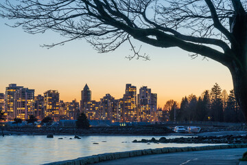 Stanley Park Seawall in dusk. Vancouver downtown skyline in the background. British Columbia, Canada.