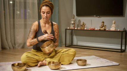 Young caucasian girl using tibetan singing bowl