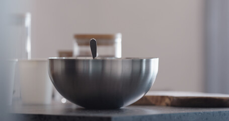 making granola in steel bowl on kitchen countertop