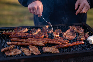 grilled meat cooked and smoked. hands turning the steak on the grill