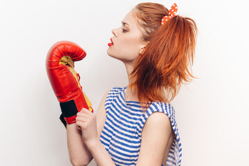 aggressive woman in red boxing gloves and a striped T-shirt bright makeup hairstyle