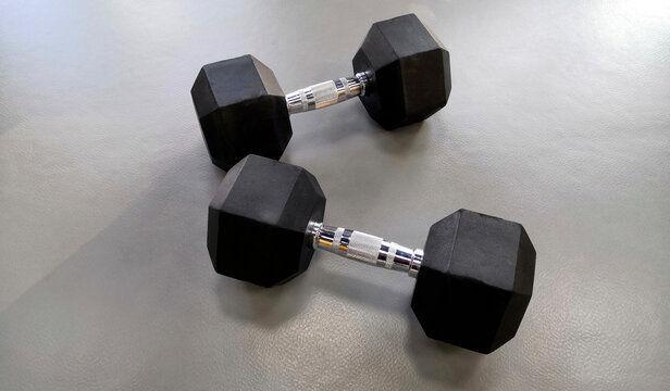 Black dumbbells on a gray background. Fitness Sports Equipment
