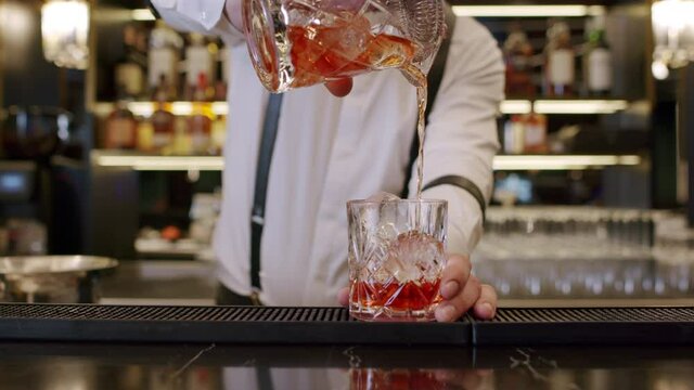 bartender mixing alcoholic cocktail in bar