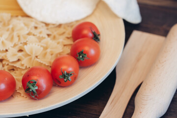 italian pasta on a wooden table cherry tomatoes cooking