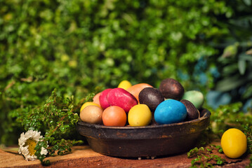 Chocolate Easter eggs with egg candies on a wooden table in the yard