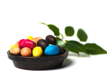 Chocolate Easter eggs with egg candies on white background