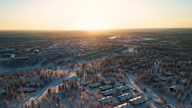 Flying over a frozen forest at sunset