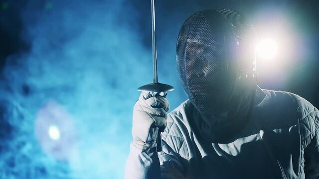 Close up of an athlete in a fencing masks preparing to attack