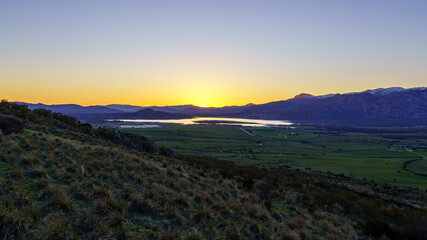 Sunset in the mountains with water lake in the valley and sun rays in the blue sky. Navacerrada Madrid.