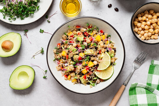 Healthy quinoa black bean salad with mango and avocado. Perfect for spring, summer, fall or winter. Gray stone background, top view. 
