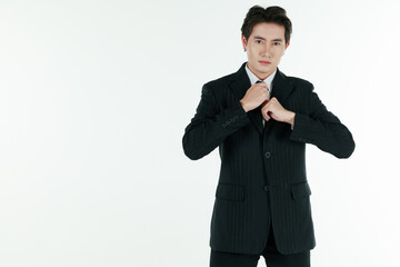 Portrait of self-confidence young and handsome Asian businessman arranging and adjust black suit with elegant pose with copy space studio shot isolated on white background