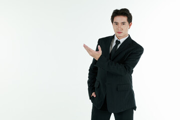 Obraz na płótnie Canvas Portrait of self-confidence young and handsome Asian businessman in black suit standing in elegant pose and pointing finger, copy space studio shot isolated on white background