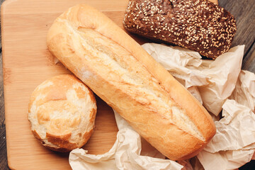 flour products loaf of bread and wood board light background