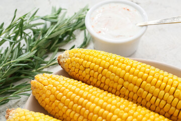 Plate with tasty baked corn cobs on table, closeup