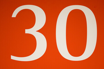 Colorful red and white sign with the number .thirty - 30
