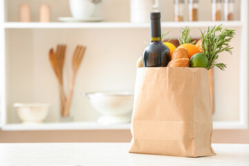 Paper bag with different products on table in kitchen