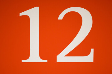 Colorful red and white sign with the number twelve - 12
