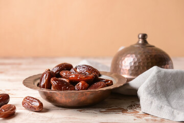 Plate with sweet dried dates on light wooden background