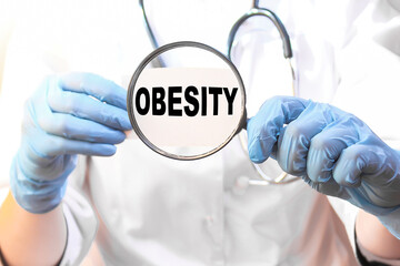 The doctor's blue - gloved hands show the word OBESITY - . a gloved hand on a white background. Medical concept. the medicine