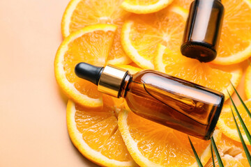 Bottles of orange essential oil on color background