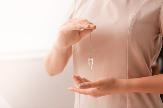 Reiki master with biolocation pendulum