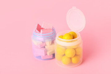 Jars with tasty chewing gums on color background