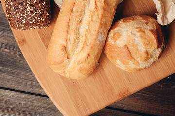 flour products loaf of bread and wood board light background