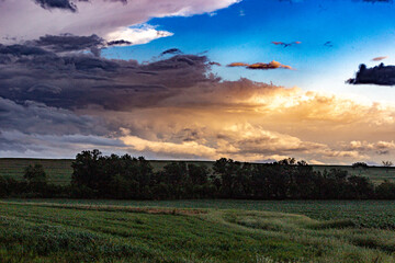 Obraz na płótnie Canvas Storm clouds at sunset over a rural landscape