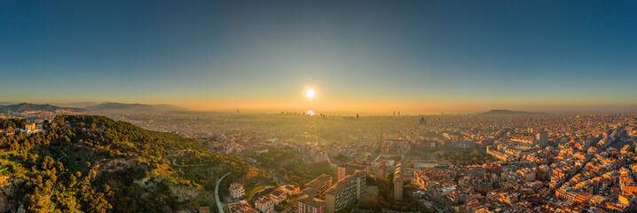 Aerial panorama drone shot of sunrise over sea horizon of Barcelona city in Spain winter dawn