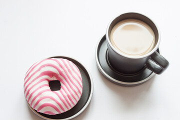 black coffee in a ceramic cup and a doughnut on rustic style table