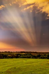 Zelfklevend Fotobehang Lichtstralen tijdens zonsondergang na een storm in een landelijk landschap © Phyre Sky