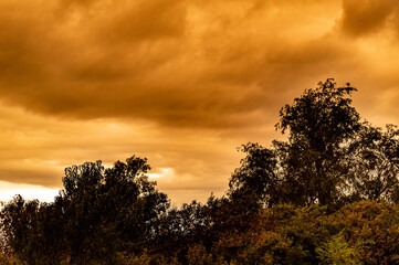 Thunderstorm clouds over a rural landscape at sunset