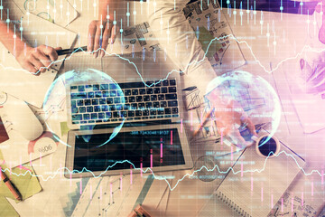 Double exposure of man and woman working together and financial graph hologram. Business concept. Computer background.