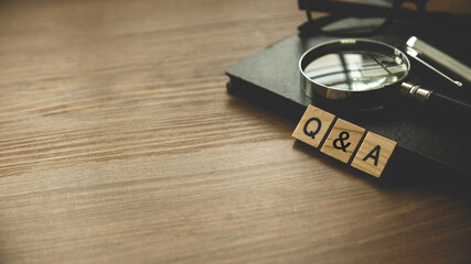 Q&A or questions and answers concept .Selective focus of  wooden alphabet ,glasses, notebook and...