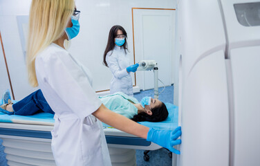 Radiologist with a female patient in the room of computed tomography