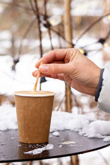 Take awy cup of coffee and female hand stirring.