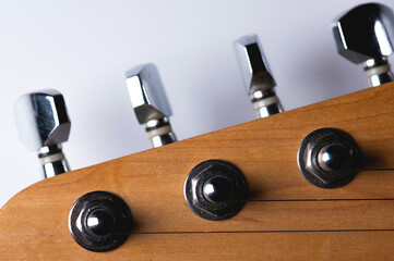 Close-up elements of electric guitar on gray background