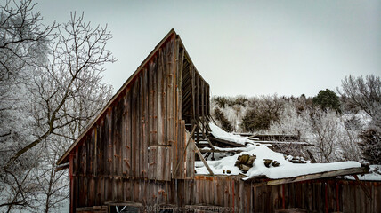 Old rundown barn covered in snow