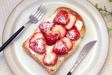 A close-up of strawberry toast on a round plate.
