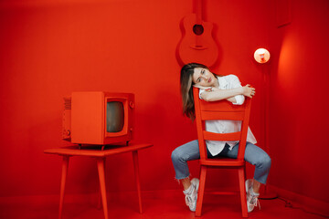 woman sitting on a chair. Isolation ina red cartoon room. High quality photo