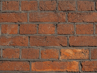 Golden brickwork made of red gold orange geometric horizontal bricks bonded with cement grout between square stones. Template background