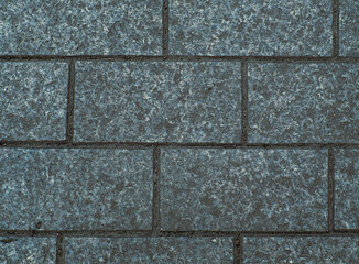 Fototapeta premium Brickwork of textured horizontal big grey bricks bonded with cement grout between square stones. Wall exterior. Background