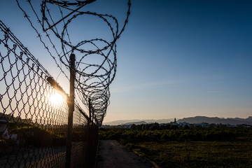 Barbed wire with spiral blades, to protect a private property outside, with the light of the sunset...
