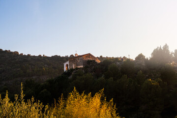 Beautiful hermitage on a small mountain, with a blue sky, at sunset.